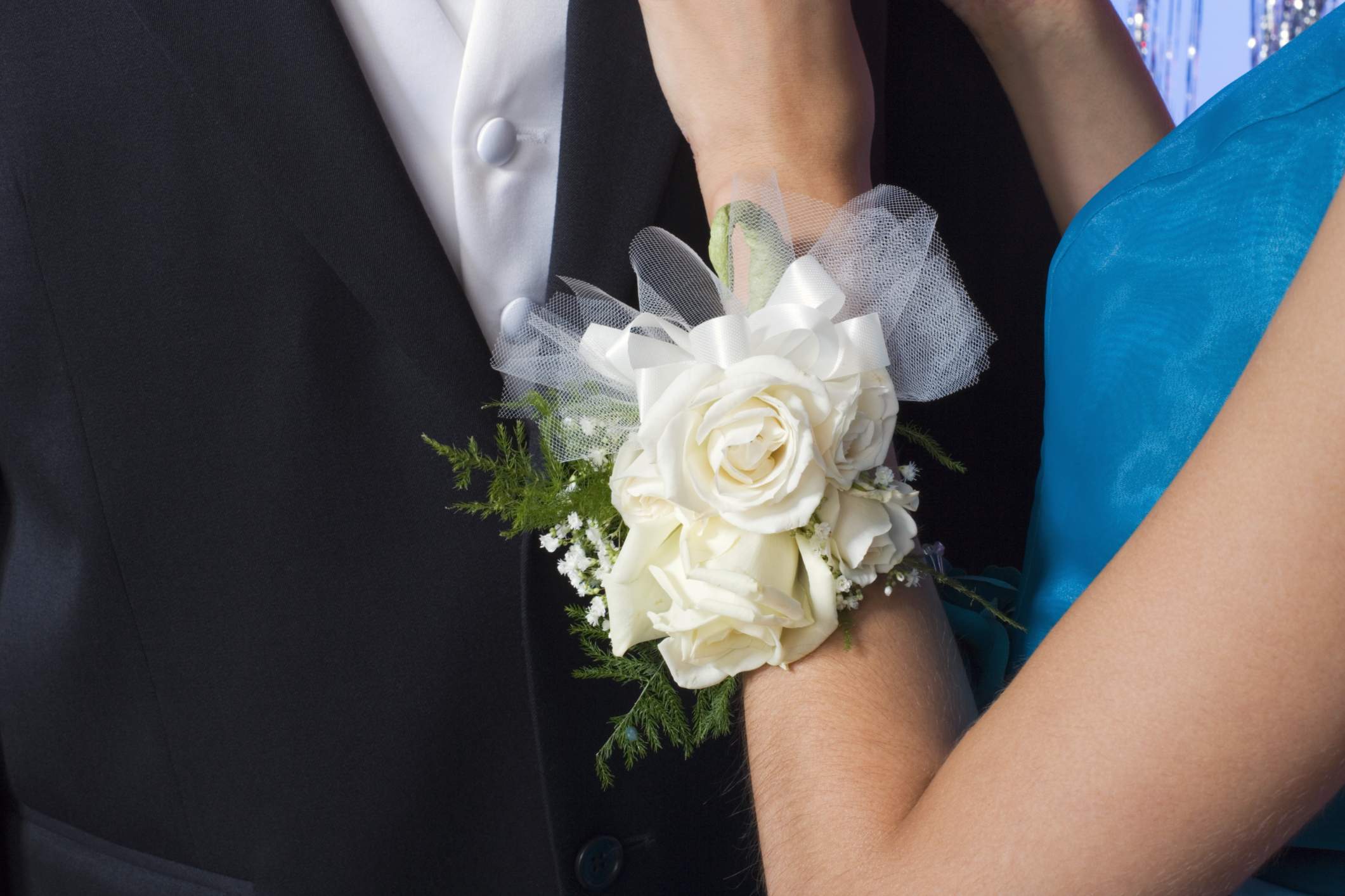 Close-up of woman's wrist wearing corsage on man's shoulder